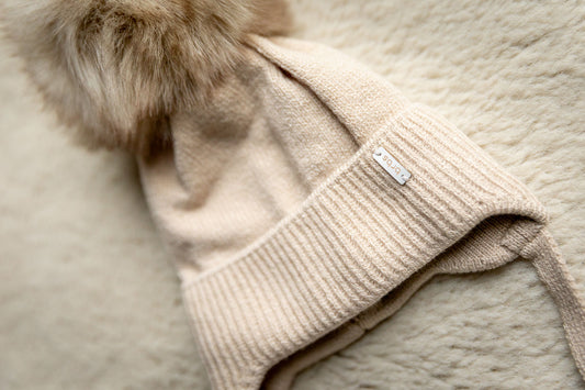 Gebreide muts met pompon ~ beige